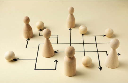 Flechas con juguetes de madera representando la organización de IA