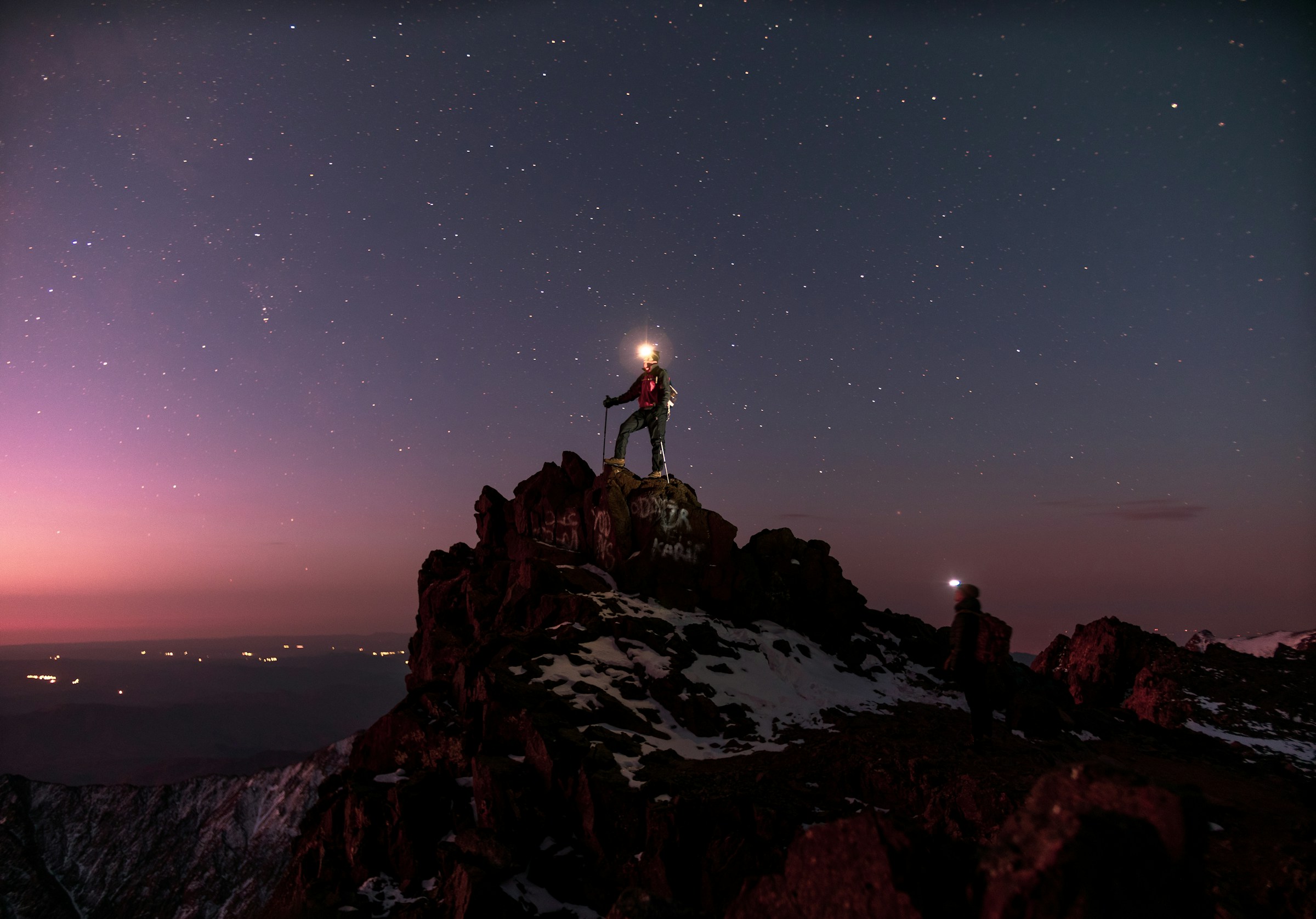 Person climbing at night with headlamp